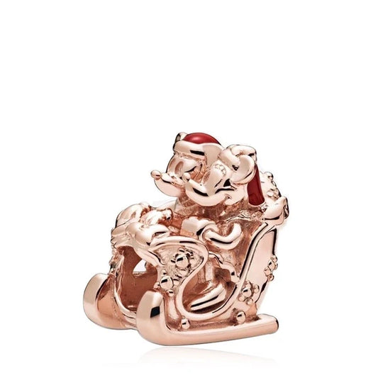 Ροζ χρυσό charm με τον Μίκυ και τη Μίνι σε χριστουγεννιάτικο έλκηθρο, διακοσμημένο με ζιργκόν και κόκκινο σμάλτο.