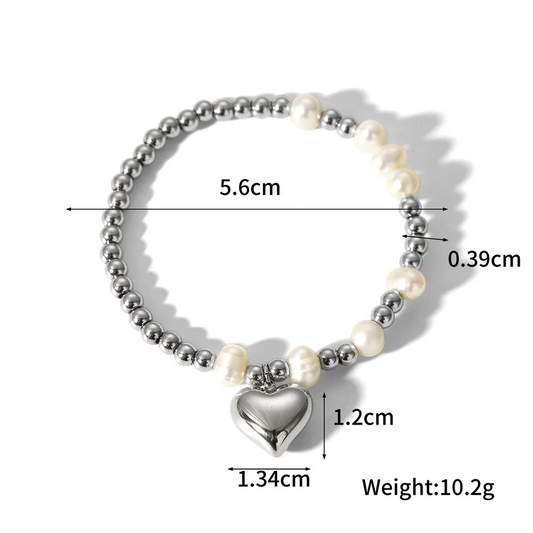 Ασημί βραχιόλι από ανοξείδωτο ατσάλι με πέρλες και charm καρδιά, διάμετρος 5.6cm, βάρος 10.2g.