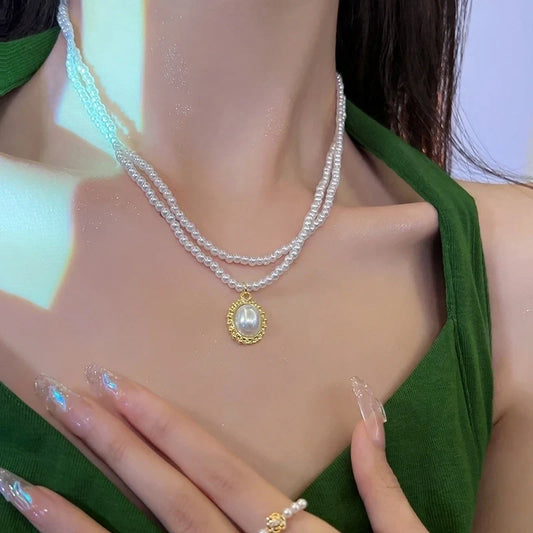 Διπλό κολιέ με λευκές χάντρες και χρυσή λεπτομέρεια με πέρλα.