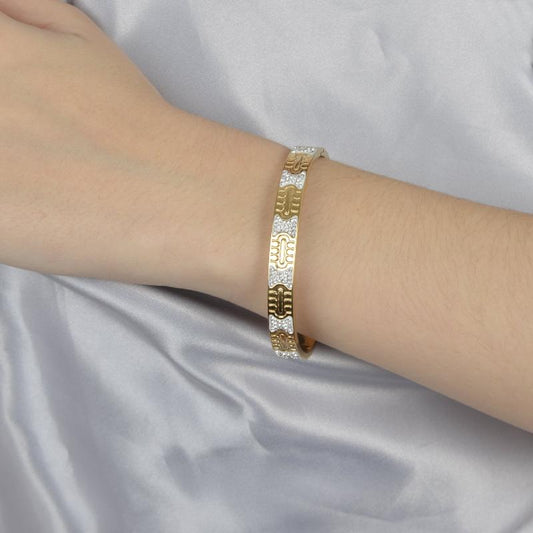 Χρυσό bangle βραχιόλι με ανάγλυφα σχέδια και στρας για λαμπερές εμφανίσεις.