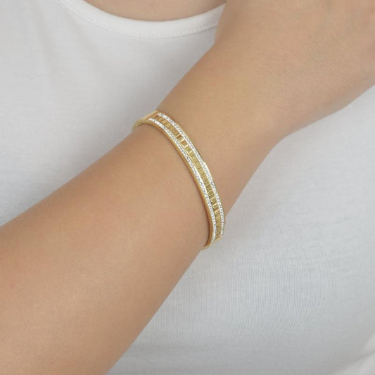 Χρυσό βραχιόλι με γεωμετρικό σχέδιο και λαμπερά ζιργκόν για μοντέρνα κομψότητα.