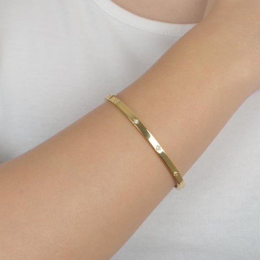 Χρυσό βραχιόλι με μινιμαλιστικό σχεδιασμό και ζιργκόν για κομψή καθημερινότητα.