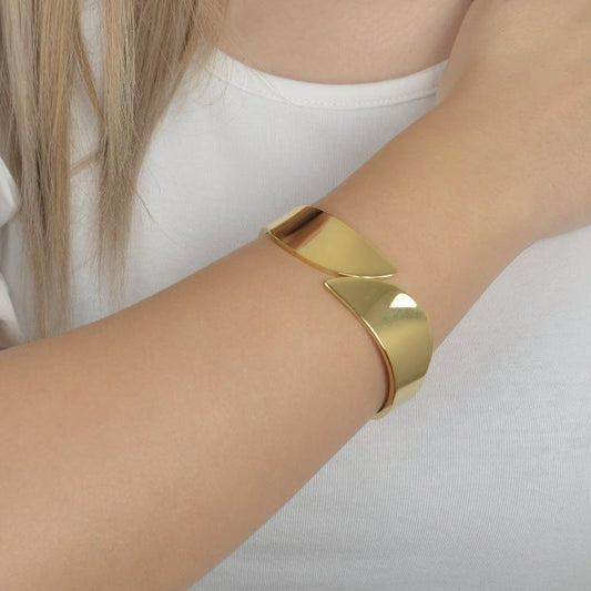 Χρυσό βραχιόλι με μοντέρνο αφαιρετικό σχέδιο για κομψές και δυναμικές εμφανίσεις.
