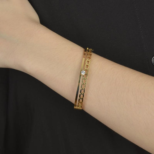 Χρυσό βραχιόλι με γεωμετρική αλυσίδα και λαμπερό διαμάντι στο κέντρο.