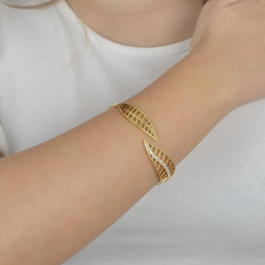 Χρυσό βραχιόλι με μοτίβο φύλλου και διακοσμητικά ζιργκόν για ρομαντική κομψότητα.