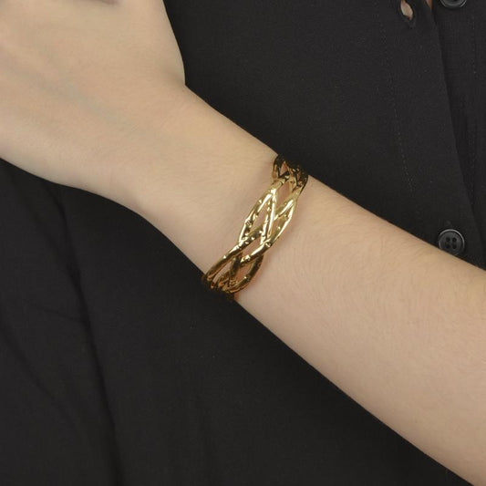 Χρυσό βραχιόλι με πλεκτό σχέδιο και λάμψη για εκλεπτυσμένες εμφανίσεις.