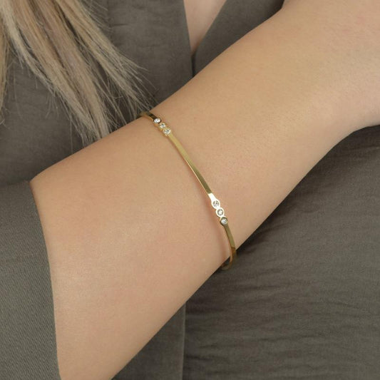 Χρυσό βραχιόλι με φύλλο και ζιργκόν για διακριτική και φυσική κομψότητα.