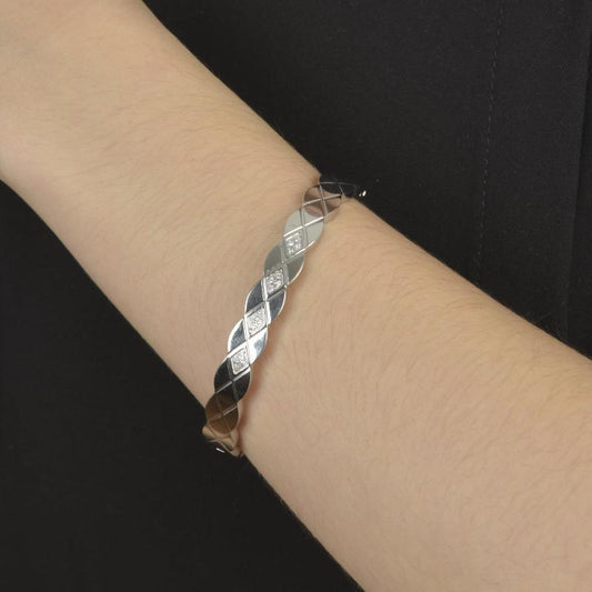 Βραχιόλι σε ασημί τόνο με διαμαντέ μοτίβο και λαμπερές λεπτομέρειες.