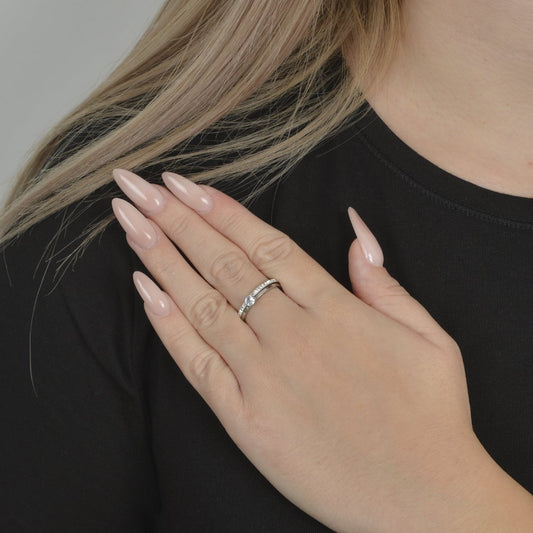 Ασημί δαχτυλίδι με διαμάντι και μικρές πέτρες.