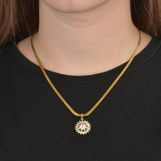 Χρυσό κολιέ με μενταγιόν ήλιου διακοσμημένο με ζιργκόν.