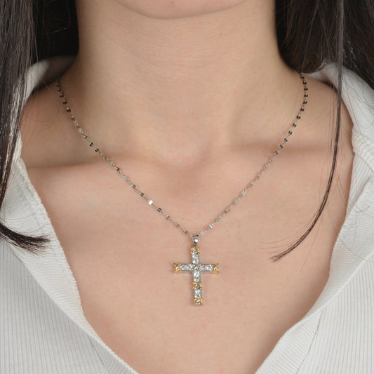 Ασημένιος σταυρός διακοσμημένος με λαμπερές πέτρες και χρυσές λεπτομέρειες.