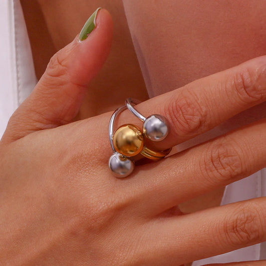 Δίχρωμο επιχρυσωμένο δαχτυλίδι από ανοξείδωτο ατσάλι 316L με τρεις σφαίρες, ύψος 31mm, βάρος 18.5g.