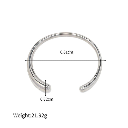 Ασημί βραχιόλι cuff από ανοξείδωτο ατσάλι με επιμετάλλωση 18Κ, διάμετρο 6.61cm και βάρος 21.92g.