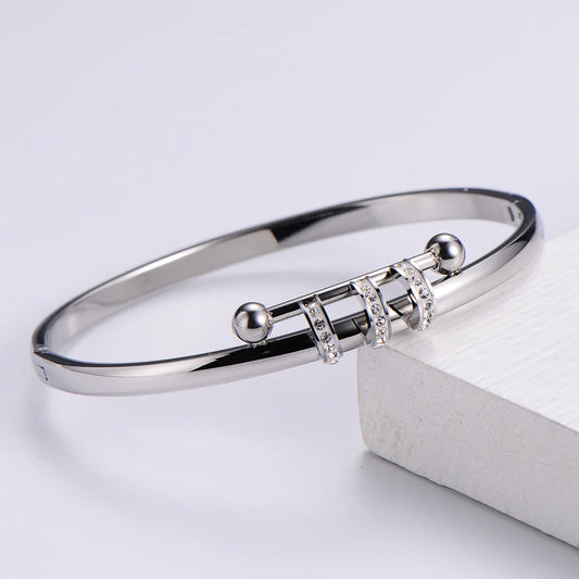 Ασημί βραχιόλι cuff από ανοξείδωτο ατσάλι με γεωμετρικές λεπτομέρειες και ζιργκόν, minimal και κομψό.