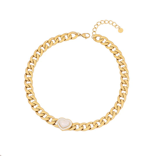 Χρυσό κολιέ με γεωμετρική αλυσίδα και καρδιά σε γυναικείο λαιμό.