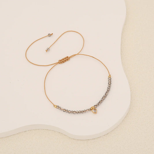 Βραχιόλι με γκρι πετραδάκια και χρυσή καρδιά.