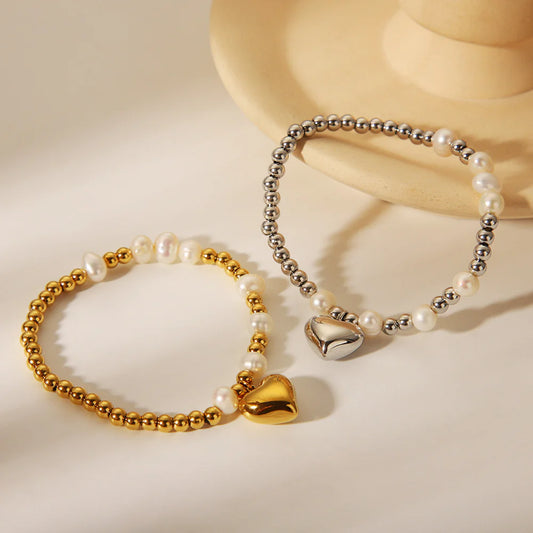 Επιχρυσωμένο βραχιόλι από ανοξείδωτο ατσάλι με πέρλες και charm καρδιά, διάμετρος 5.6cm, βάρος 10.2g.