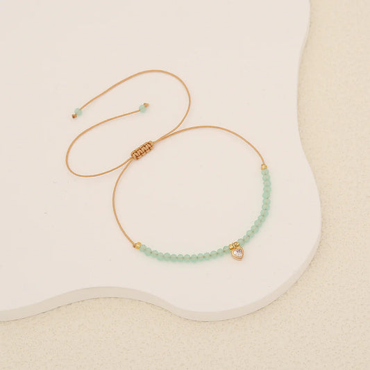 Βραχιόλι με γαλάζια πετραδάκια και χρυσή καρδιά με κρύσταλλο.