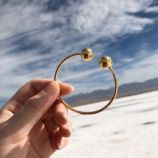 Χρυσό βραχιόλι με δύο στρογγυλές άκρες και μοντέρνο ανοιχτό σχέδιο