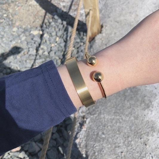 Χρυσό βραχιόλι με δύο στρογγυλές άκρες και μοντέρνο ανοιχτό σχέδιο