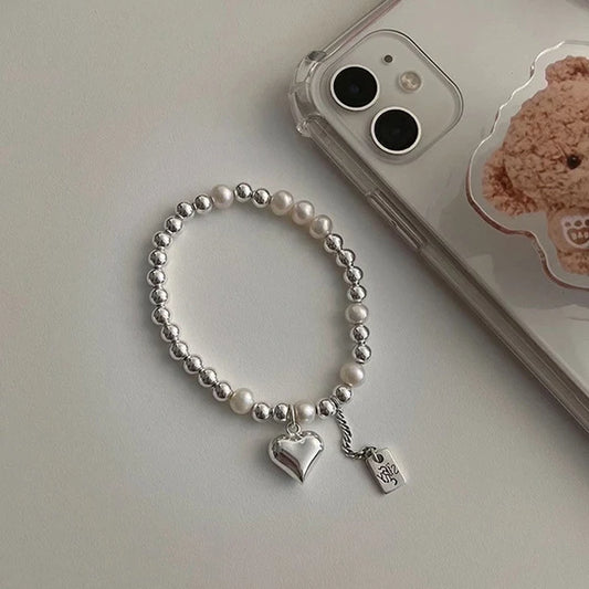 Ασημένιο επιχρυσωμένο βραχιόλι με χάντρες και καρδιά.