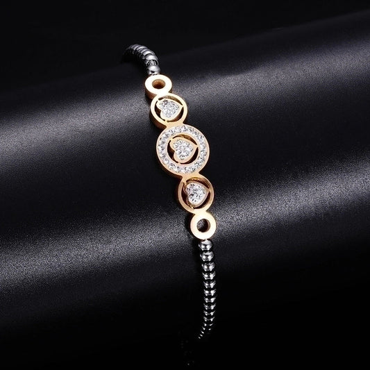 Βραχιόλι με χρυσές καρδιές και τεχνητούς πολύτιμους λίθους από τιτάνιο χάλυβα.