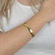 Χρυσό minimal cuff βραχιόλι με γυαλιστερή επιφάνεια για εκλεπτυσμένες εμφανίσεις.

